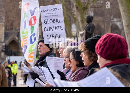 Raised Voices Chor bei Youth Strike 4 Climate Protest auf Parliament Square, London, Großbritannien. Politischer Chor demonstriert für Maßnahmen zur Erderwärmung Stockfoto
