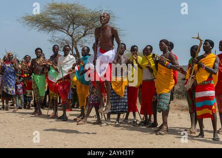 Eine Gruppe junger Samburu-Männer, die in traditioneller Kleidung gekleidet sind und einen traditionellen Springtanz in einem Dorf in Samburu in der Nähe des Samburu National Reserve ausführen Stockfoto