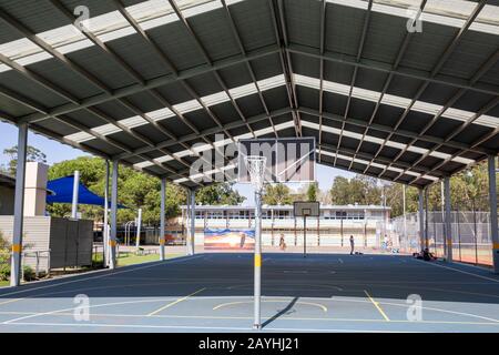 Australische Schule mit Outdoor-Sport- und Basketballplatz unter einer Dachkonstruktion für Schatten, Sydney, Australien Stockfoto