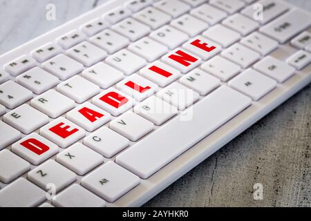 Weiße Computertastatur mit roten Tasten, die mit den Worten 'Deadline' angeordnet sind. Planungskonzept Stockfoto