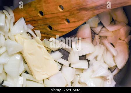 Frisch gehackte Zwiebel mit Butter in einem Topf sautieren Stockfoto