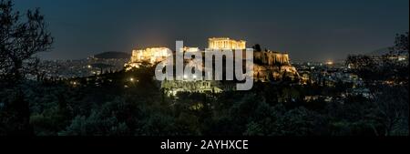 Panoramablick auf Athen mit Akropolis-Hügel bei Nacht, Griechenland. Die berühmte Akropolis ist ein Wahrzeichen Athens. Antike griechische Ruinen im Zentrum von Athen Stockfoto