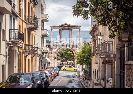 Straße in Athen mit Blick auf das alte Hadrianstor oder den Hadriansbogen in Griechenland. Es ist ein Wahrzeichen Athens. Blick auf den historischen Stadtteil in der Ath Stockfoto