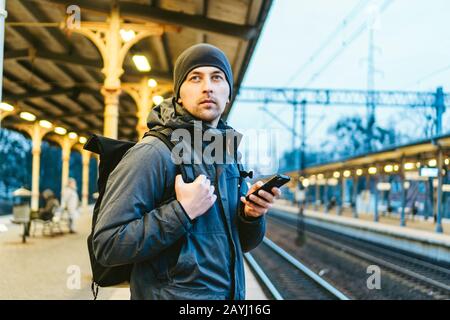 Bahnhof in Sopot, Polen, Europa. Attraktiver Mann wartet am Bahnhof. Mit Rucksack an die Reise denken. Reisefotografie. Tourist Stockfoto