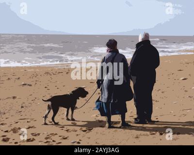 Mann und Frau, die an einem Strand stehen und mit einem Hund an der Leine ins Meer schauen Stockfoto