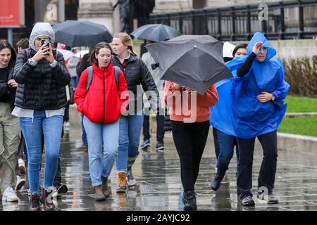 Menschen kämpfen mit Regenschirmen im Zentrum Londons bei nassem und windigem Wetter.Sturm Dennis wird am Wochenende starken Regen und starken Wind über Großbritannien bringen. Stockfoto