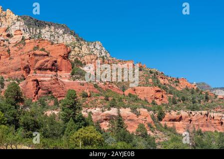 Niedrige Baumlandschaft und Grün auf einem Hügel aus rotem und weißem Stein im Slide Rock State Park in Sedona, Arizona Stockfoto