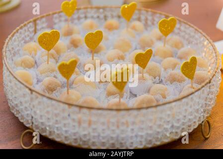 Nahaufnahme von Beijinho' (wörtlich: Kleiner Kuss) auf weißem Tablett, typisch brasilianische Süßigkeiten mit Kondensmilch, Kokos und Kristallzucker, Erfolg in birt Stockfoto