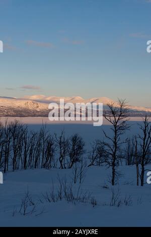 Blick vom Hotel Fjallet auf den gefrorenen und schneebedeckten Tornetrasksee im schwedischen Lappland, Nordschweden. Stockfoto