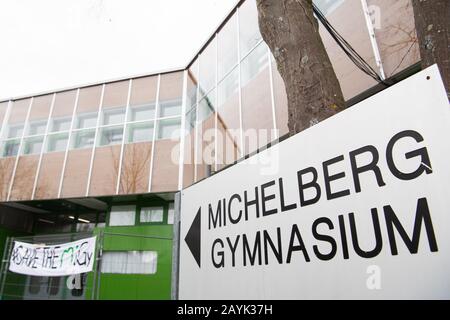 Geislingen An Der Steige, Deutschland. Februar 2020. Der Schriftzug "Wichelberg-Gymnasium" befindet sich vor der Schule. Im Hintergrund befindet sich ein Banner mit der Aufschrift "Save THE MiGy". Nach der Sanierung der Schule hatten Experten im vergangenen Jahr Mängel festgestellt. Kultusminister Eisenmann (CDU) setzt sich nun für den Erhalt der Schule ein. Kredit: Tom Weller / dpa / Alamy Live News Stockfoto