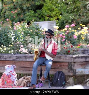 Portland, Oregon USA - 16. Juni 2018: Ein Straßenmusiker spielt auf einem Saxofon in einem Rose Garden Park Stockfoto