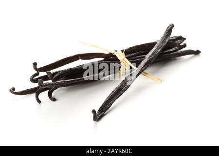 Bündel gebundener, getrockneter Bourbon-Vanille-Bohnen oder -Schoten über weißem Hintergrund - selektiver Fokus Stockfoto