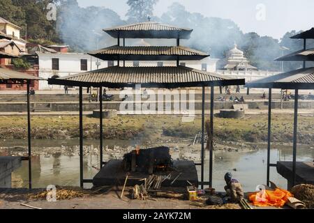 Hindu-Menschen, die ihre Toten im Weltberühmten Pashupatinath-Tempel-Komplex am Ufer des Bagmati-Flusses in Kathmandu, Nepal, verbrennen Stockfoto