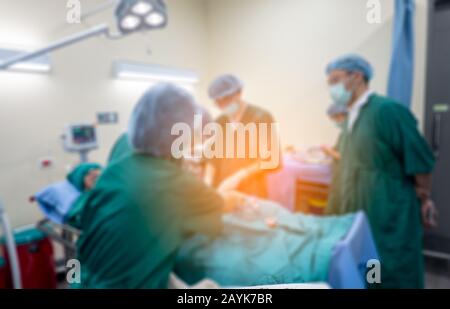Verschwommener Hintergrund des modernen Operationssraums im Krankenhaus mit Gruppe von Chirurgen im Operationssaal mit chirurgischen Geräten. Moderner medizinischer Hintergrund Stockfoto