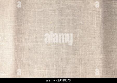 Beige Leinenstoff aus Baumwolle für Tapete. Hintergrundtextur aus brauner Webwolle. Stockfoto
