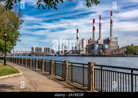 New YORK, USA - 13. OKTOBER: Riverside Walking Path in Roosevelt Island mit Blick auf die "Ravwood Generating Station" am 13. Oktober 2019 in New Yor Stockfoto