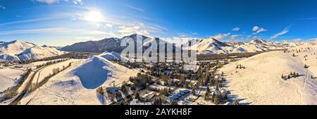 Malerisches Winterpanorama mit schneebedeckten Tälern und Bergketten unter hellem Sonnenlicht, Sun Valley, Idaho Stockfoto