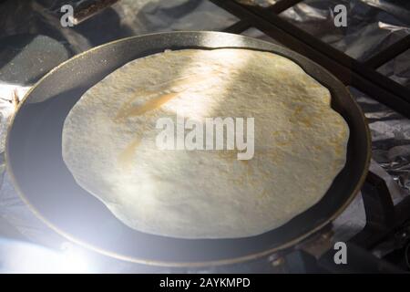 Dünne Pfannkuchen in einer Bratpfanne in der Küche auf einem Gasherd Stockfoto