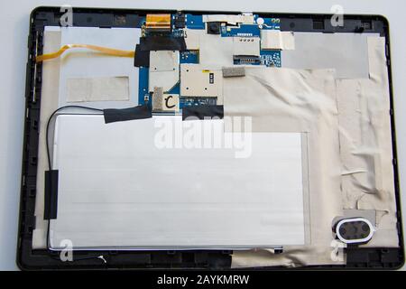 Zerlegter Tablet-Computer mit defektem Touchscreen-Display ohne Abdeckung auf der Rückseite. Professionelle Reparatur moderner Geräte Stockfoto