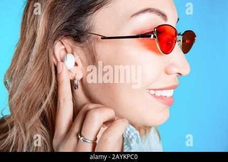Asiatische Mädchen hören Musik von modernen kabellosen Kopfhörern im Studio Stockfoto