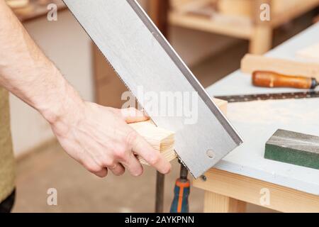 Tischler Arbeitet mit Säge auf einer Baustelle, Arbeitssicherheitskonzept Stockfoto