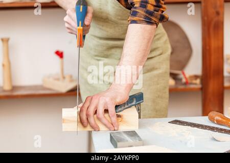 Tischler Arbeitet mit Säge auf einer Baustelle, Arbeitssicherheitskonzept Stockfoto