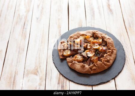 Galette mit Birnen und Käsebrie. Auch bretonische Galette genannt, Galette des Rois, Galeta. Französische Küche. Auf altem weißen Holzhintergrund. Stockfoto