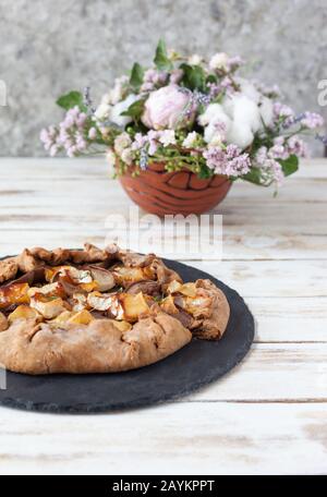 Galette mit Birnen und Käsebrie. Auch bretonische Galette genannt, Galette des Rois, Galeta. Französische Küche. Auf altem weißen Holzhintergrund. Stockfoto