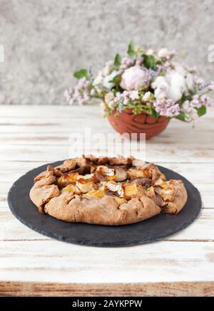 Galette mit Birnen und Käsebrie. Auch bretonische Galette genannt, Galette des Rois, Galeta. Französische Küche. Auf altem weißen Holzhintergrund. Stockfoto