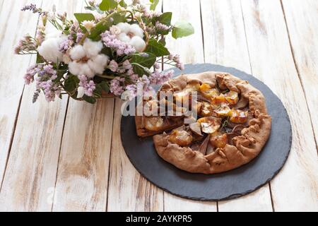 Galette mit Birnen und Käsebrie. Auch bretonische Galette genannt, Galette des Rois, Galeta. Französische Küche. Auf altem weißen Holzhintergrund. Stockfoto