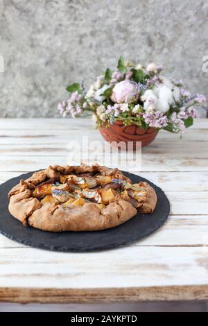 Galette mit Birnen und Käsebrie. Auch bretonische Galette genannt, Galette des Rois, Galeta. Französische Küche Auf altem weißen Holzhintergrund. Stockfoto