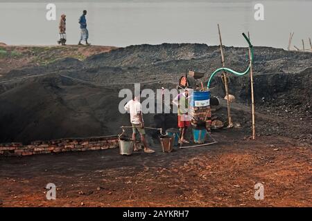 Ein Arbeiter trägt Ziegelsteine bei Maurer in Khulna, Bangladesch. Stockfoto