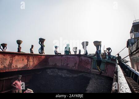 Der Arbeiter trägt einen Korb Kohle, der im Brennofen eines Maurers verwendet werden soll.Khulna, Bangladesch. Stockfoto