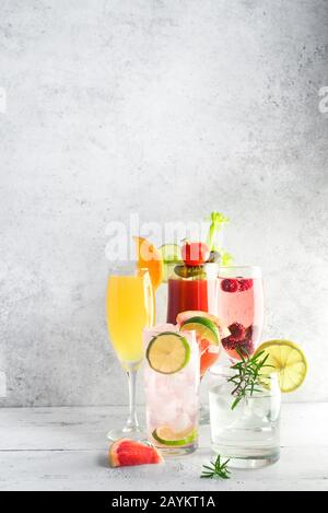 Brunch- oder Frühstückscocktails. Bloody Mary, Mimosa Drink und verschiedene erfrischende Cocktails aus Zitrusalkohol auf leichtem Tisch, Kopierraum. Stockfoto