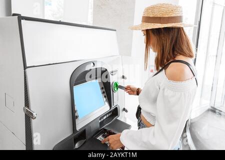 Frau zieht Geld mit Plastikkarte am Geldautomaten ab. Finanz- und Cashflow-Konzept Stockfoto