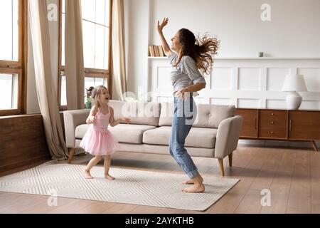 Verrückte, energische Familie von zwei Tänzen im Wohnzimmer. Stockfoto