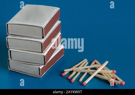 Vier Schachtel mit Matches und neuen Matches auf blauem Hintergrund. Selektiver Fokus. Nahaufnahme. Stockfoto