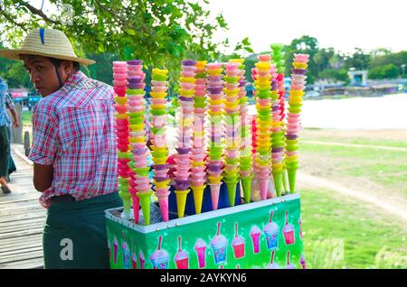 Lokale Birmanesen verkaufen Eiscreme mit einem Wagen voller farbiger Eiskegel. An der U-Bein-Brücke, Amarapura, Mandalay, Myanmar Stockfoto