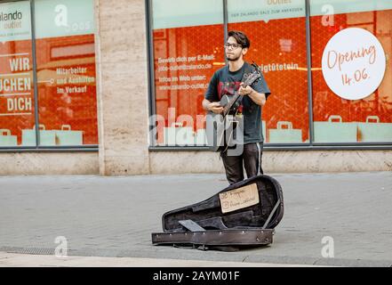 22. MAI 2018, LEIPZIG, DEUTSCHLAND: Junger Hipper spielt auf der Straße Gitarre. Rockstil Stockfoto