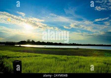 Foto aufgenommen an der U-bein-Brücke mit Blick auf das goldene grüne Feld und den Taungthaman Lake am Nachmittag. Amarapura, Mandalay, Myanmar. Stockfoto