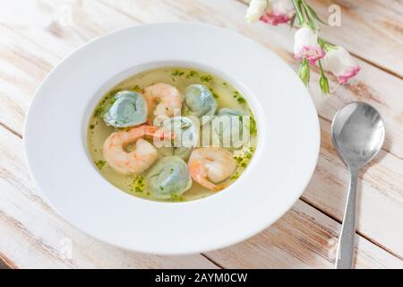 Suppenklöße und Garnelen werden mit Lauch serviert. Auf altem weißen Holzhintergrund. Stockfoto