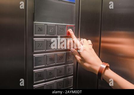 Die Hand drückt auf die Hubtaste des Elevators Stockfoto