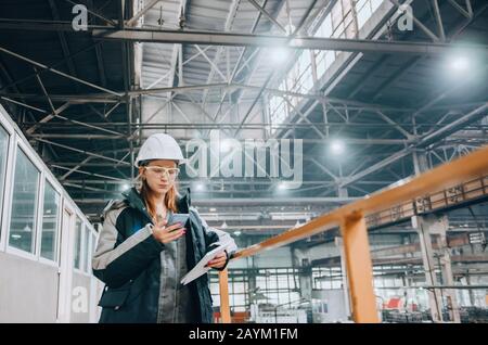 Produktion Werkstatt. Junge Ingenieurin in der modernen Fabrik arbeiten Stockfoto