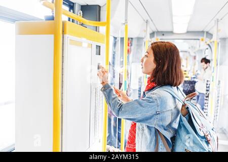 Frau kauft Fahrkarte in Straßenbahn oder Bus, Konzept des öffentlichen Verkehrs Stockfoto