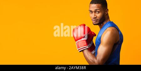 Porträt eines selbstbewussten schwarzen Mannes mit roten Boxhandschuhen Stockfoto