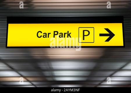 Gelbes Parkschild mit Pfeil zur Parkzone am Flughafenterminal Stockfoto