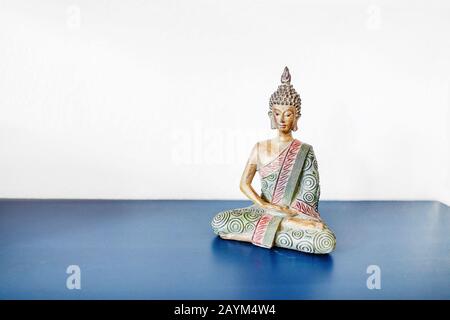Kleine Buddhastatue auf einem Tisch Stockfoto