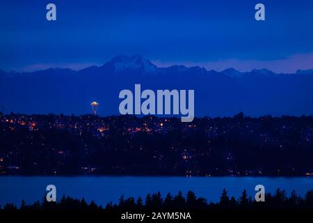 Blick auf die Stadt Seattle bei Nacht und den Olymp im Hintergrund mit Häusern, Washington See vor Bellevue, WA, USA Stockfoto