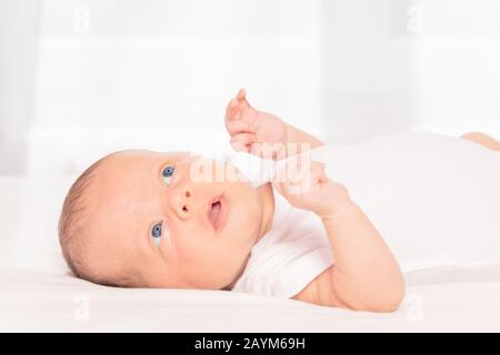 Portrait des neugeborenen Säuglings, der auf der Rückseite des Raumes liegt Stockfoto
