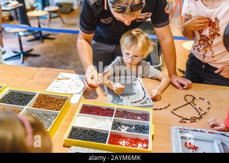 Berlin, DEUTSCHLAND - 19. MAI 2018: Kinder mit Eltern beschäftigen sich mit Beadwork und Handarbeit, Hobbykonzept Stockfoto